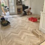 visgraat houten vloer gelegd door De Oude Plank. Experts is vloeren met karakter. Monteur is de vloer aan het leggen in een woning.